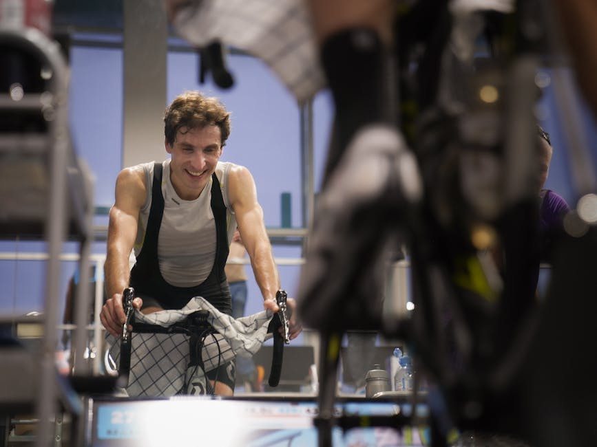 Man doing an intense indoor cycling workout on a stationary bike, demonstrating the cardiovascular and fitness benefits of indoor cycling