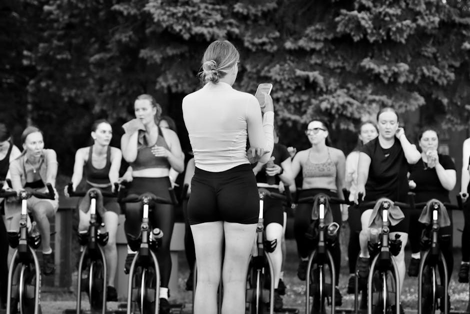 Instructor leading a spin class on stationary bikes — calories burned depend on body weight and session intensity