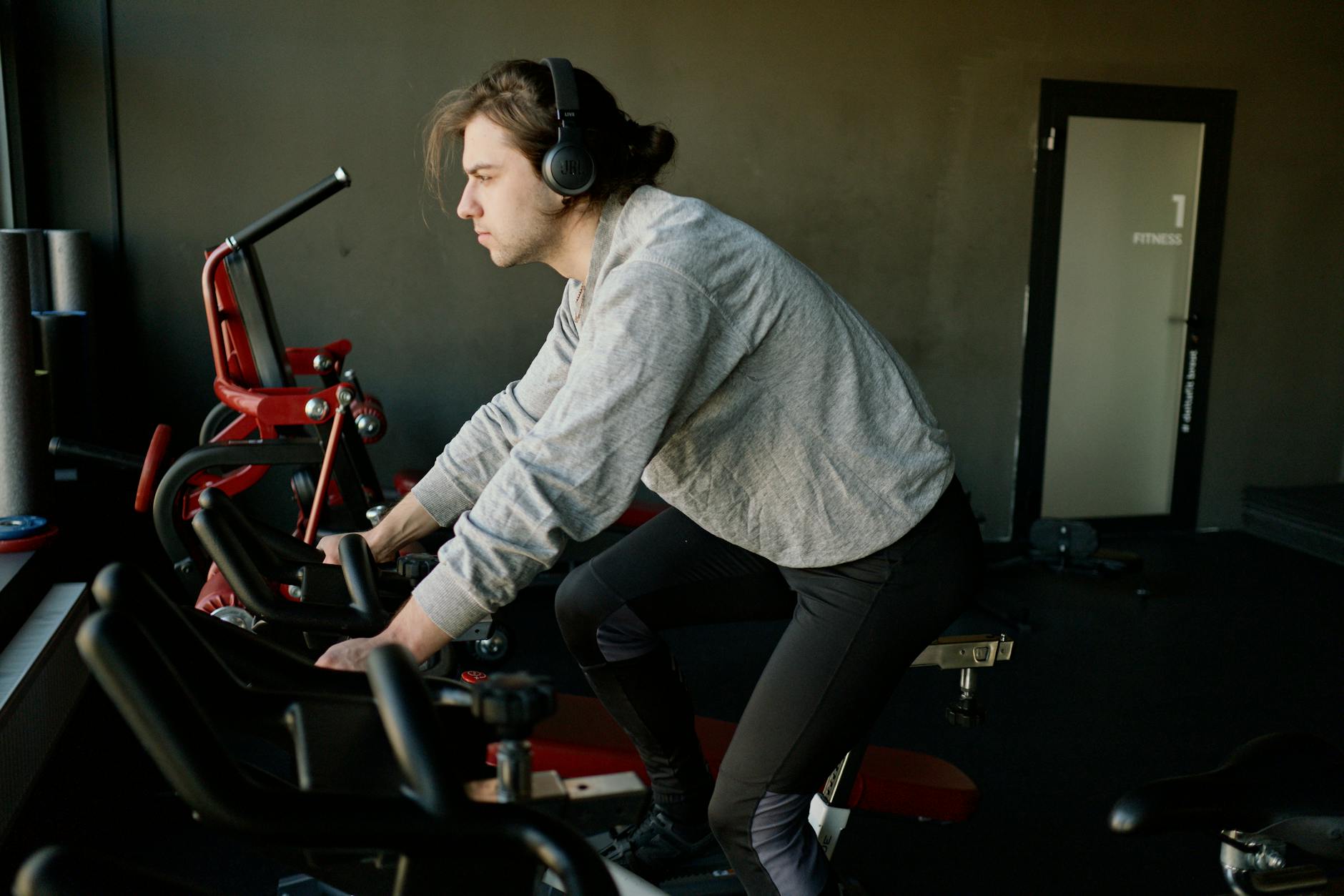 Man riding a compact exercise bike in a modern home gym setting